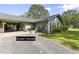 Charming guest house with blue siding, a carport, and inviting landscaping, set on a sunny day at 2400 Commack Ct, New Port Richey, FL 34655