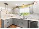Updated kitchen features modern gray cabinets, granite countertops, subway tile backsplash, and stainless steel appliances at 2400 Commack Ct, New Port Richey, FL 34655