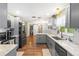 Modern kitchen with grey cabinets, granite countertops, stainless steel appliances, and wood floors at 2400 Commack Ct, New Port Richey, FL 34655
