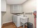 Laundry room features white appliances, utility sink, and storage cabinets at 2400 Commack Ct, New Port Richey, FL 34655