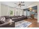 Bright living room featuring dark brown leather couches, lots of natural light, and wood floors at 2400 Commack Ct, New Port Richey, FL 34655