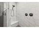 Modern shower features white marbled tile, a built-in seat, and matte black shower head and fixtures at 2400 Commack Ct, New Port Richey, FL 34655