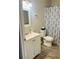 Bright bathroom features a vanity with a white countertop and a shower with a patterned blue curtain at 2729 Penzance St, Palm Harbor, FL 34684