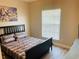 Bedroom with a neutral palette, ceiling fan, wood-look flooring, and a large window at 2729 Penzance St, Palm Harbor, FL 34684