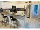 Open kitchen with white cabinets, stainless steel appliances, granite counters and breakfast bar seating at 2729 Penzance St, Palm Harbor, FL 34684