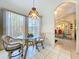 Charming breakfast nook featuring a glass table, wicker chairs, and a stained glass pendant lamp for a cozy dining experience at 3054 Oakbrook Cir, Clearwater, FL 33759