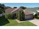 Charming single-story home featuring a two-car garage, well-manicured lawn, and mature landscaping at 3054 Oakbrook Cir, Clearwater, FL 33759
