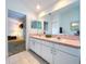 Bright main bathroom featuring dual sinks, vanity, and access to a private bath and shower area at 3054 Oakbrook Cir, Clearwater, FL 33759