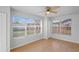 Light-filled bedroom with large windows, hardwood floors, and a contemporary ceiling fan at 3141 Loomis Dr, New Port Richey, FL 34655