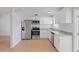 Stylish kitchen features stainless steel appliances, white cabinetry, granite counters and hardwood flooring at 3141 Loomis Dr, New Port Richey, FL 34655