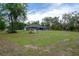 Expansive backyard featuring lush green grass, mature trees, and a screened-in pool enclosure at 3355 La Vista St, Brooksville, FL 34604