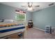 Bright bedroom featuring a ceiling fan, window, comfortable bed, and playful decor at 3355 La Vista St, Brooksville, FL 34604