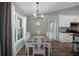 Dining room features a long table with seating for eight, chandelier, and adjacent kitchen at 3355 La Vista St, Brooksville, FL 34604
