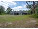 View of the rear exterior with a screened pool and a spacious yard, perfect for relaxing or activities at 3355 La Vista St, Brooksville, FL 34604