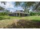 A sprawling home with a wide, covered front porch and lush, natural landscaping at 3355 La Vista St, Brooksville, FL 34604