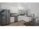 Bright kitchen with stainless appliances, stone counters, white cabinets, and adjacent dining area at 3355 La Vista St, Brooksville, FL 34604
