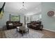 Open-concept living room featuring wood-look tile, a neutral rug, and comfortable leather sofas at 3355 La Vista St, Brooksville, FL 34604