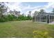 Inviting screened pool area surrounded by ample green space and lush foliage, offering privacy at 3355 La Vista St, Brooksville, FL 34604