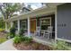 Inviting front porch with rocking chairs, complemented by lush landscaping and charming architectural details at 3355 La Vista St, Brooksville, FL 34604