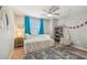 Comfortable bedroom with a stylish daybed, blue curtains, hanging chair, and bookshelf at 3555 Bracknell Ct, Land O Lakes, FL 34638