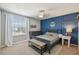 Stylish bedroom with blue accent wall, window with blinds, and classic furnishings at 3555 Bracknell Ct, Land O Lakes, FL 34638