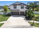 Lovely two-story home featuring a three-car garage, landscaped lawn, and a welcoming entrance at 3555 Bracknell Ct, Land O Lakes, FL 34638