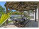 Backyard gazebo with a picnic table, overhead fans, and string lights, ideal for outdoor gatherings at 3555 Bracknell Ct, Land O Lakes, FL 34638