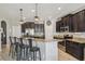 Kitchen featuring granite counters, dark cabinets, stainless appliances and bar top seating at the island at 3555 Bracknell Ct, Land O Lakes, FL 34638