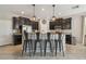 Kitchen island with seating, stainless steel appliances, dark wood cabinets and granite countertops at 3555 Bracknell Ct, Land O Lakes, FL 34638