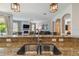 A kitchen with a double sink looks into a living room with a fireplace and entertainment center at 3555 Bracknell Ct, Land O Lakes, FL 34638