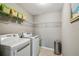 Functional laundry room equipped with modern washer and dryer and shelving for organization at 3555 Bracknell Ct, Land O Lakes, FL 34638