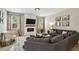 Cozy living room boasts a modern fireplace, TV, neutral tones, and large gray sectional at 3555 Bracknell Ct, Land O Lakes, FL 34638