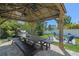 Charming outdoor dining area features a wooden table, benches, and gazebo with ambient lighting at 3555 Bracknell Ct, Land O Lakes, FL 34638