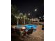 Backyard pool with pergola, fire pit and patio furniture under string lights at 3555 Bracknell Ct, Land O Lakes, FL 34638