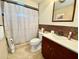 Bathroom with dark wood vanity, tiled floor, and shower with curtain at 3752 Fox Dale Ln, Holiday, FL 34691