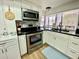 Modern kitchen with stainless steel appliances, granite countertops, tile backsplash, and white cabinetry at 3752 Fox Dale Ln, Holiday, FL 34691