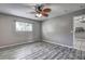 Bedroom featuring wood-look floors, ceiling fan and a window providing natural light at 4030 Casa Del Sol Way, New Port Richey, FL 34655