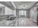 Bright kitchen with white tile flooring, granite countertops, and stainless sink at 4030 Casa Del Sol Way, New Port Richey, FL 34655