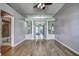 Open floorplan living room featuring wood floors, fan, and opening to dining room at 4030 Casa Del Sol Way, New Port Richey, FL 34655