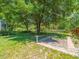 Lush backyard featuring a brick path, large trees, and green grass at 446 Romine Ct, Spring Hill, FL 34609