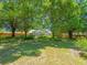 Large, private backyard featuring mature trees providing ample shade, and a screened lanai for year-round enjoyment at 446 Romine Ct, Spring Hill, FL 34609