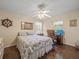 Cozy bedroom with a decorative ceiling fan, wooden floors, and a desk by the window at 446 Romine Ct, Spring Hill, FL 34609