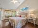 Bedroom with vaulted ceiling, two windows, a bed, and a vanity with chair, and wood-look floors at 446 Romine Ct, Spring Hill, FL 34609