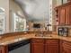 Stylish kitchen featuring granite countertops, wood cabinets, and a breakfast bar overlooking the living room at 446 Romine Ct, Spring Hill, FL 34609