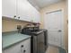 Laundry room featuring front loading washer and dryer, cabinets, and green counters at 446 Romine Ct, Spring Hill, FL 34609
