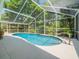 Inviting screened-in pool area with lush landscaping, providing a private retreat at 446 Romine Ct, Spring Hill, FL 34609