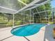 Inviting screened-in pool area with lush landscaping, providing a private retreat at 446 Romine Ct, Spring Hill, FL 34609
