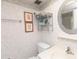 Compact bathroom with a patterned wall, round mirror, and essential storage shelves at 4726 Marine Pkwy # 201, New Port Richey, FL 34652