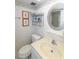 Simple bathroom featuring a round mirror, storage shelves, and a standard white toilet at 4726 Marine Pkwy # 201, New Port Richey, FL 34652