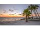 Picturesque beach view featuring palm trees, colorful sunset, and serene ocean at 4726 Marine Pkwy # 201, New Port Richey, FL 34652